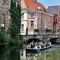 Toeristen in bootje varen onder brug over de Kleine Nete te Lier, België
